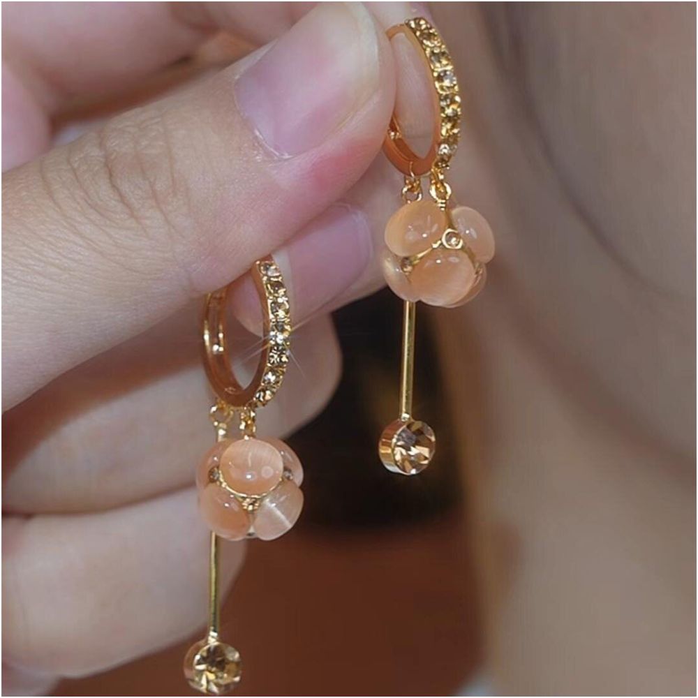 Spring and summer new cat eye stone ball tassel earrings for women with a high end feel micro inlaid ear buckles light luxury temperament face slimming earrings